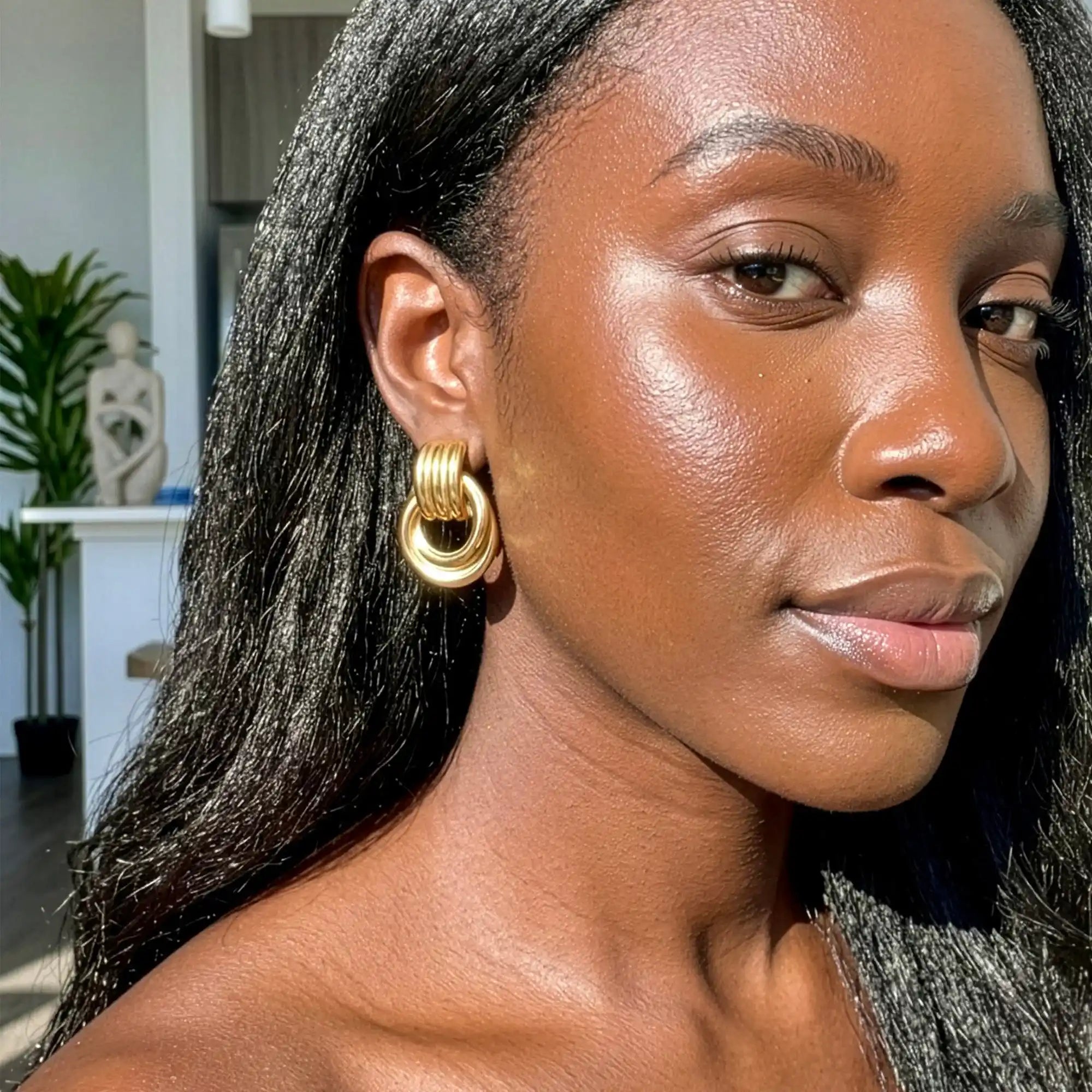 Riva Sculptural Knot Earrings gold on model ear — Tamola Jewellery