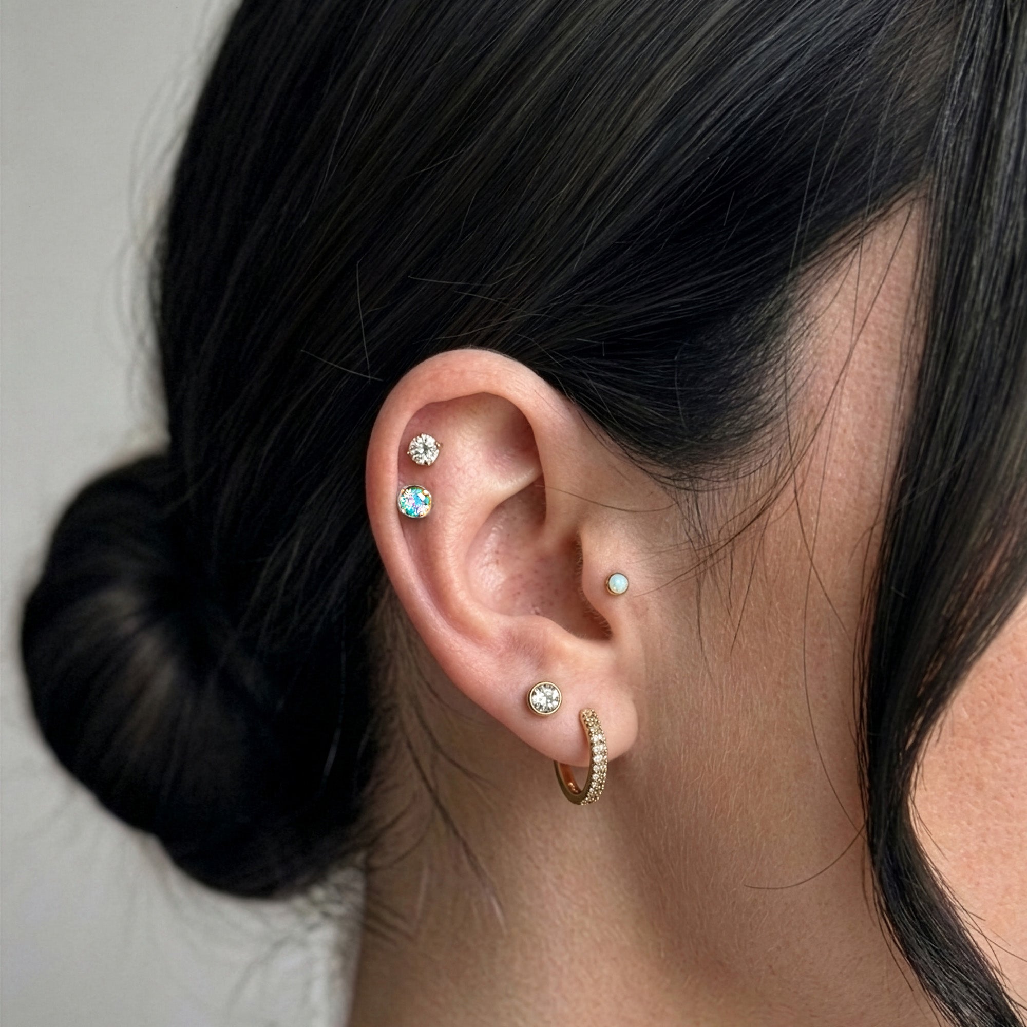 Lumiere Piercing Stack gold on model ear — Tamola Jewellery