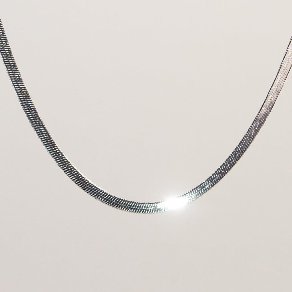 Saga Flat Snake Chain Necklace silver stainless steel on model neck — Tamola Jewellery